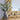 Decorative gold ornate frame of the Envy Mirror with a vase of eucalyptus on a wooden surface.