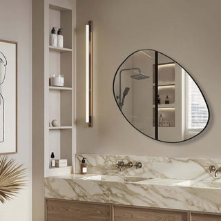 Elegant oval mirror in modern bathroom with stylish lighting and marble countertop.