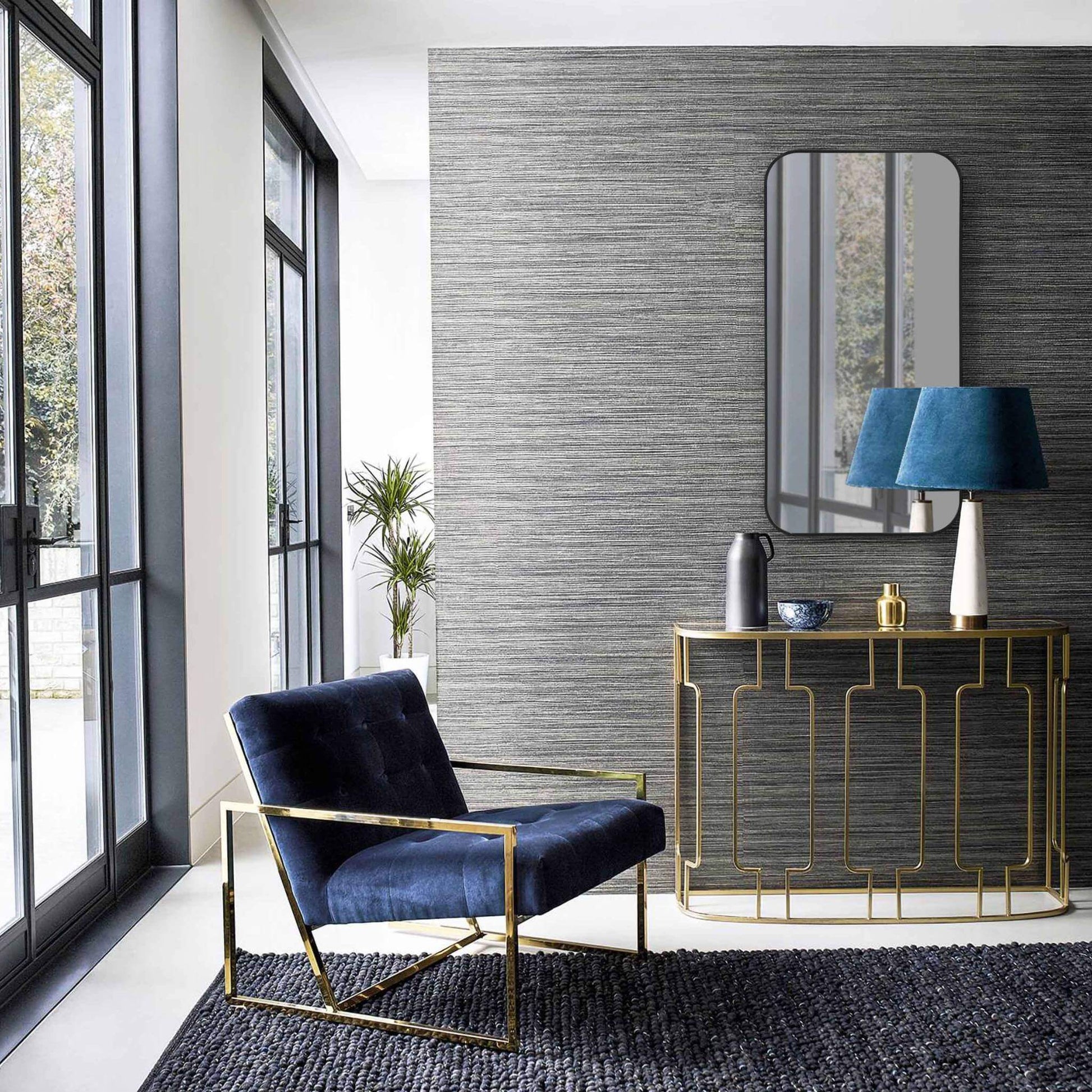 Elegant living room featuring a large aluminum frame mirror above a stylish console table and modern blue chair.
