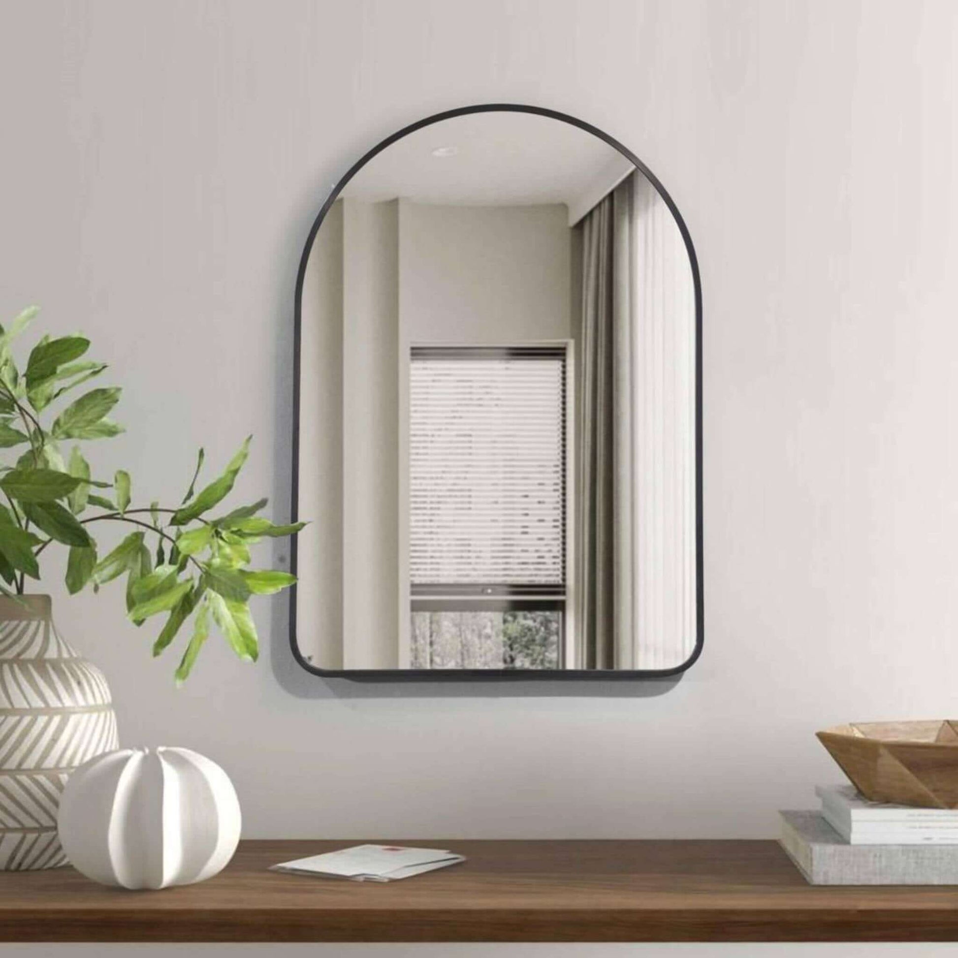 Rounded Crescent Mirror Small in sleek black frame, enhancing modern interior decor with minimalist elegance.