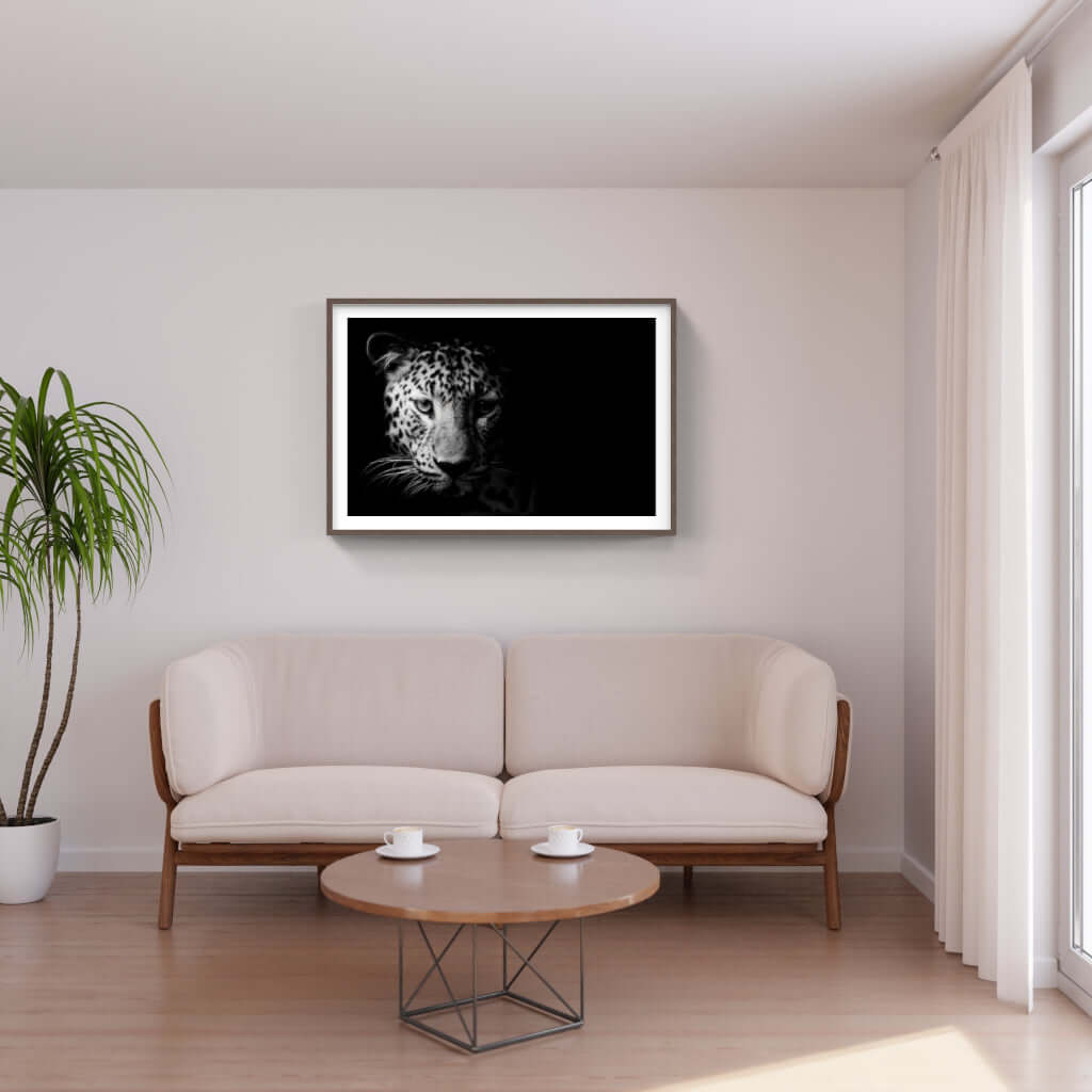 Framed leopard artwork on wall above modern sofa in a stylish living room setting.