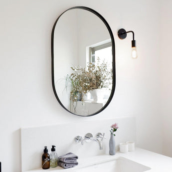 Aura Mirrror Small in Black placed above a bathroom sink.