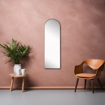 Crescent Mirror Large in Black hung on a wall between an armchair and coffee table