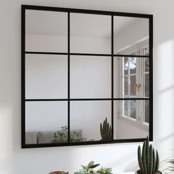 Dutch Square Mirror with a black metal frame mounted on a wall, reflecting a bright and airy room.