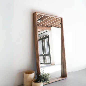 The Jupiter Mirror in a mahogany finish showcased in a passageway setting.