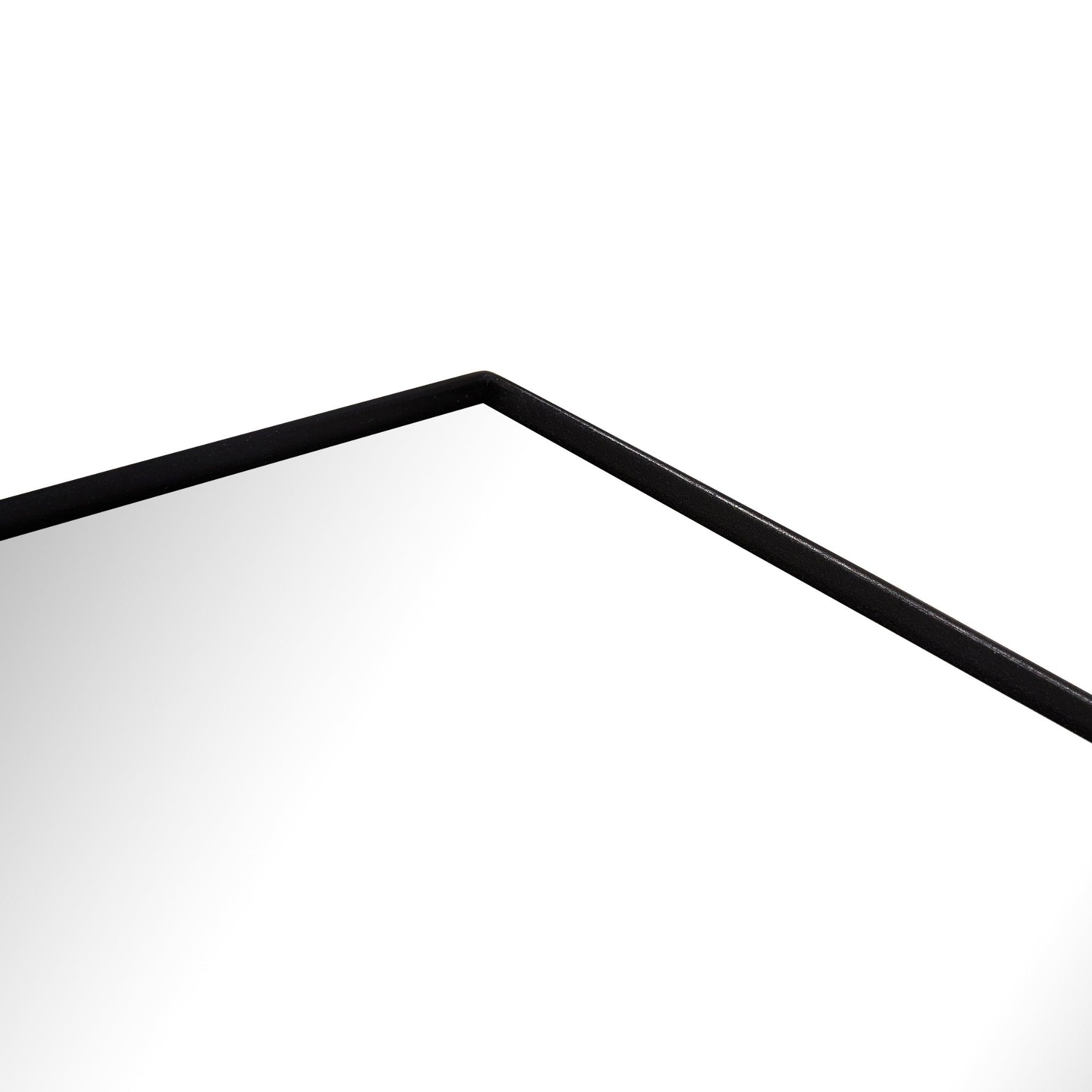 Close-up of the black metal frame corner of a medium industrial mirror, showcasing its sleek design.