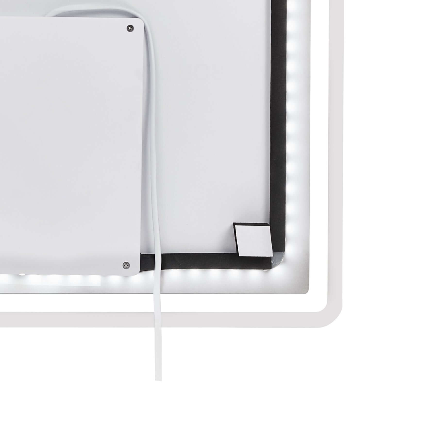 Close-up of the backlit edge of a rectangle frameless LED mirror showcasing integrated lighting features.
