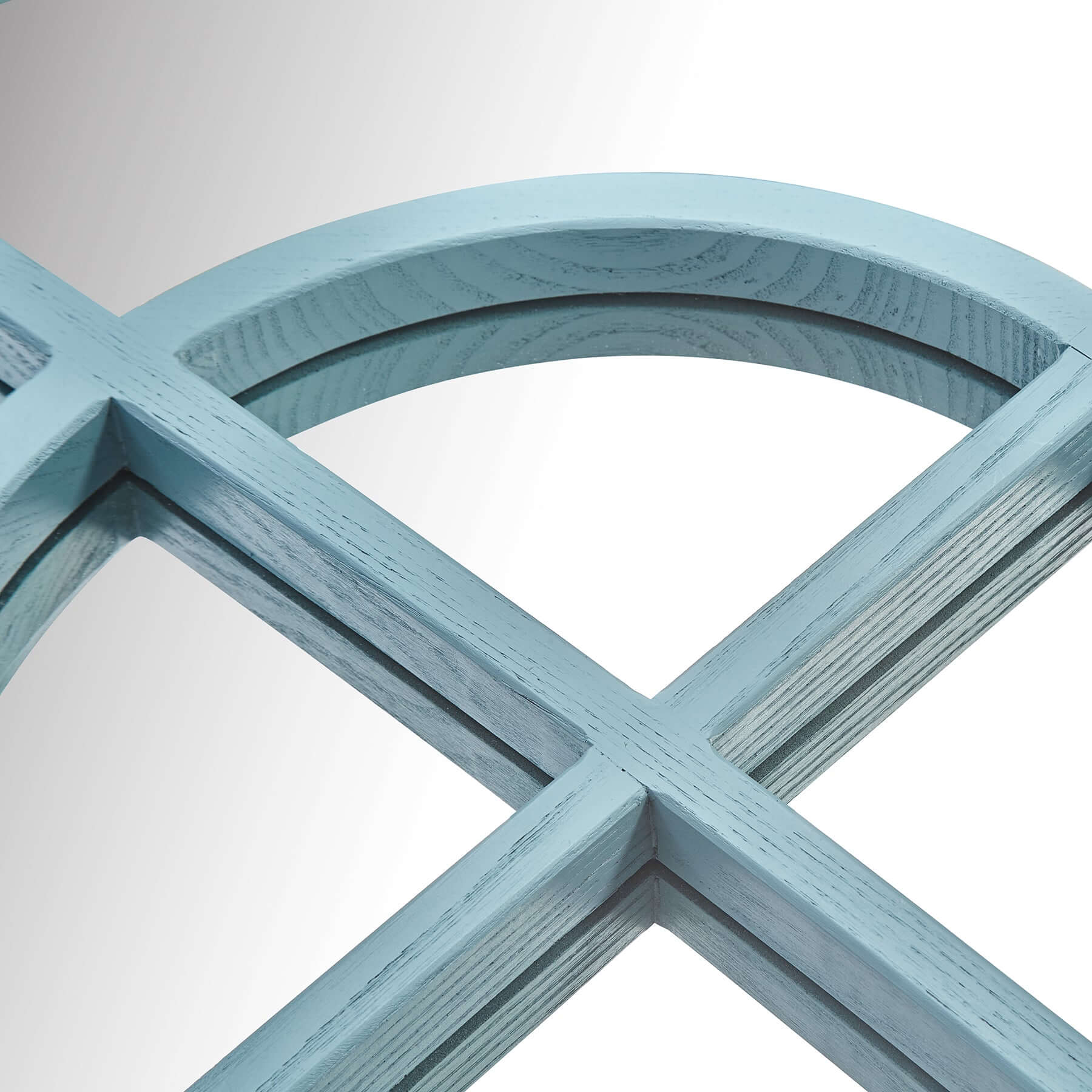 Close-up of the Arch Mirror's blue wood-styled resin frame with arched top and windowpane design.