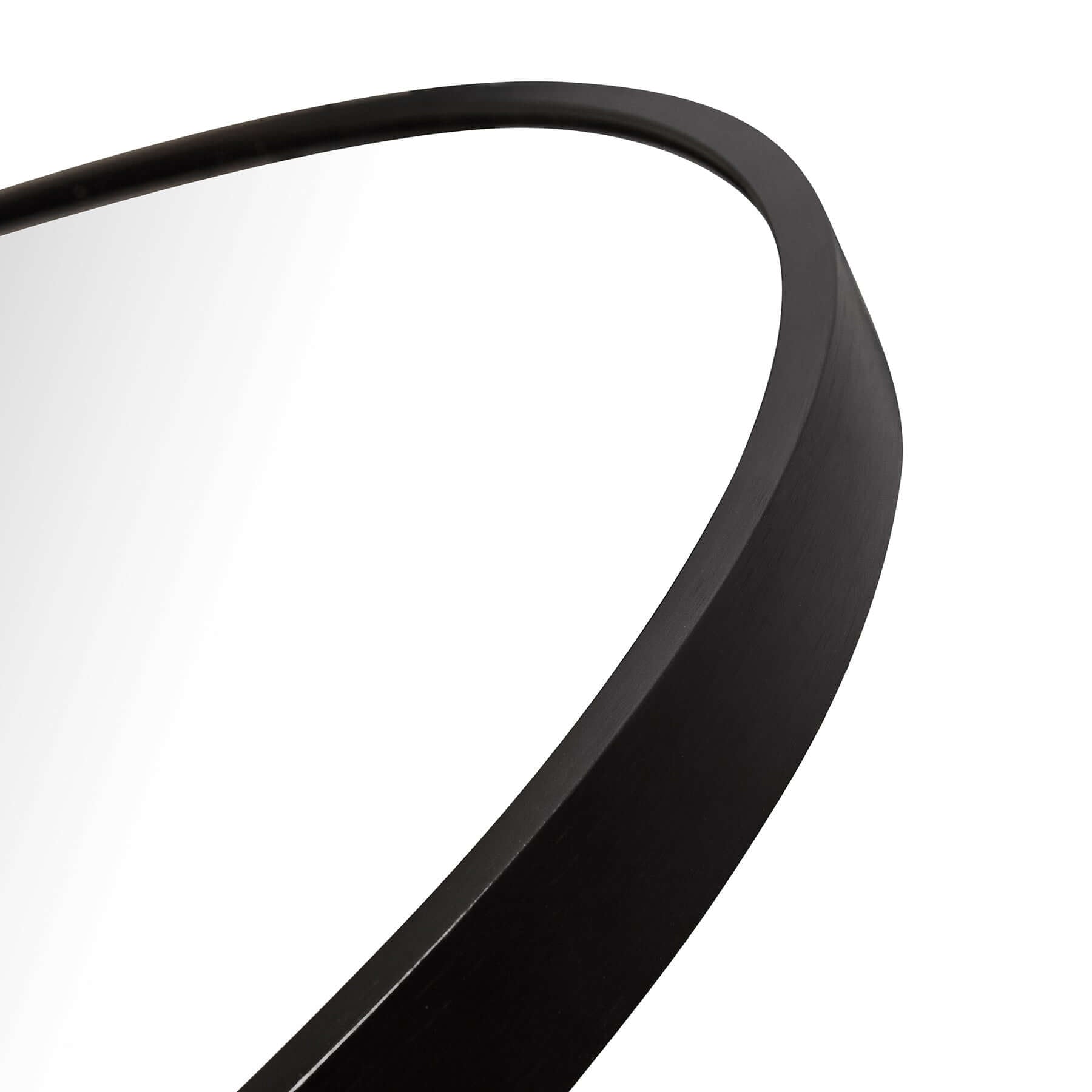 Close-up of a large oval aluminium mirror with a sleek black frame, showcasing modern minimalist design.