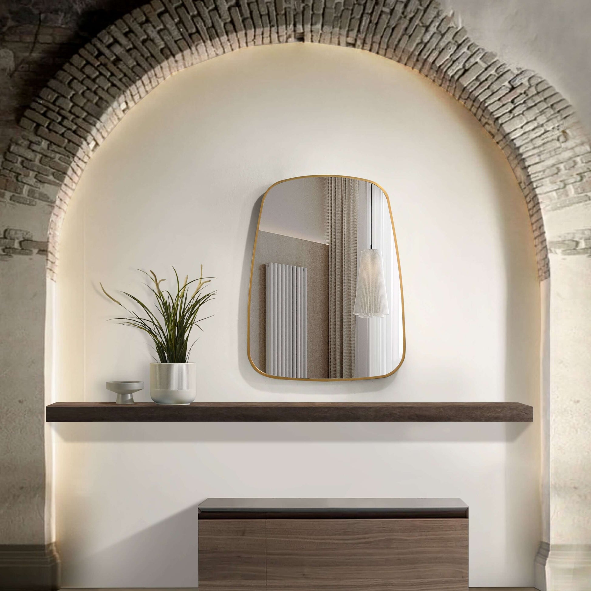 Aluminium frame mirror with softly curved edges above a wooden shelf, enhancing a modern home interior.