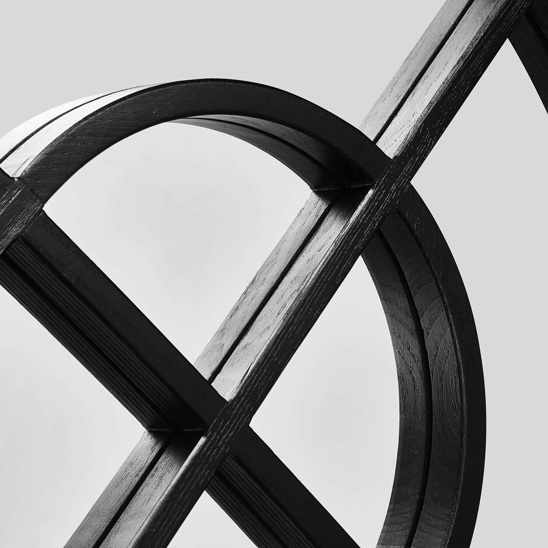 Close-up of an artistic wooden structure with curved arches and intersecting lines in black and white.
