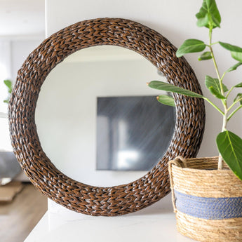 Wicker Rpund Mirror in Mahogany finish styled ontop of a countertop