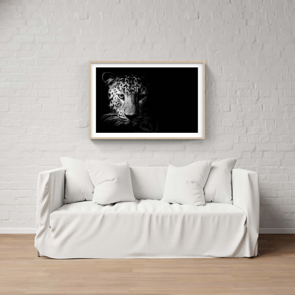 Framed black and white leopard artwork above a white sofa in a modern interior.