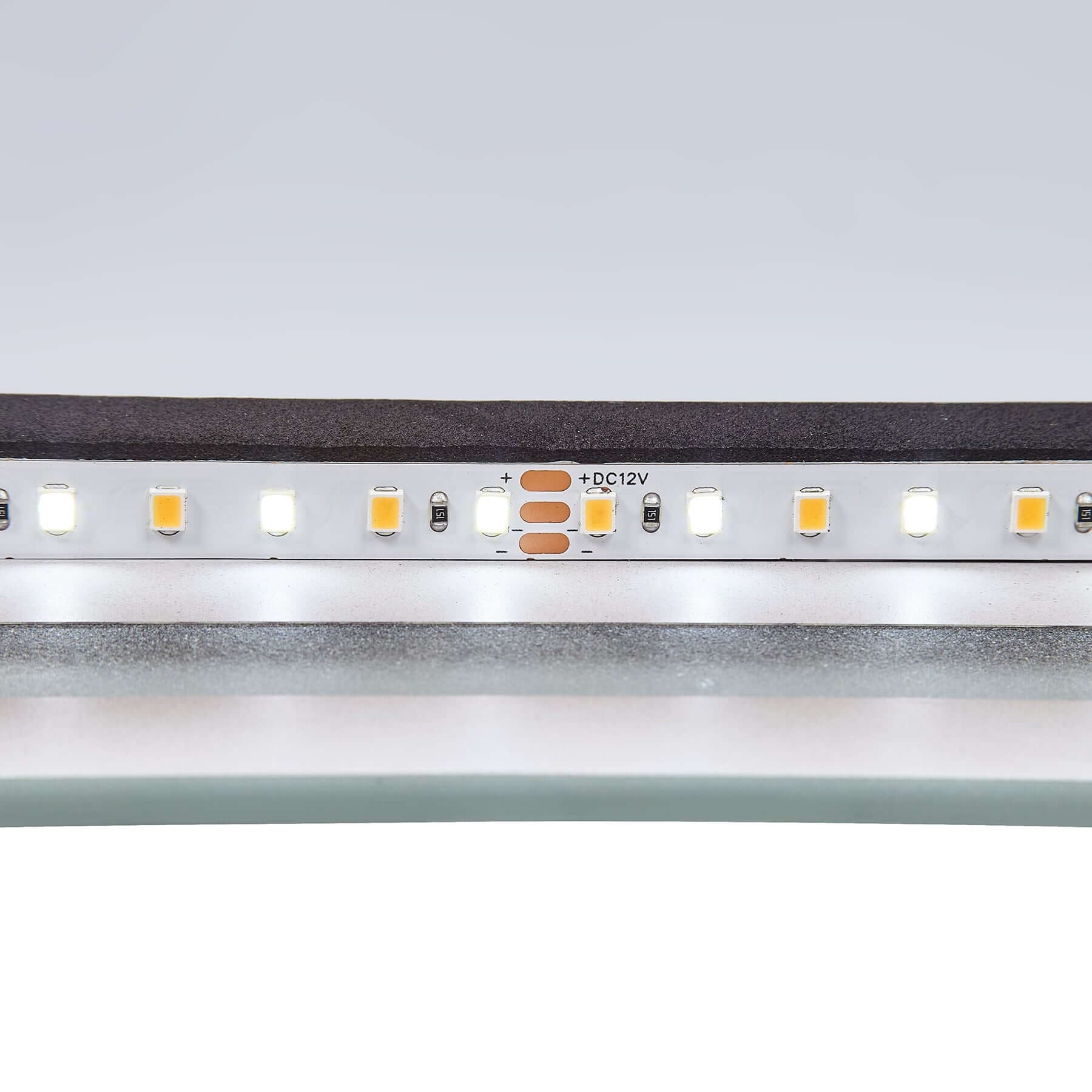 Close-up view of LED strip lights on the Crescent Frameless LED Mirror showcasing installation details.
