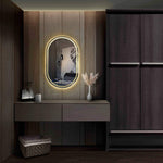 Oval frameless LED mirror with integrated backlighting, enhancing modern interior decor in a stylish room.