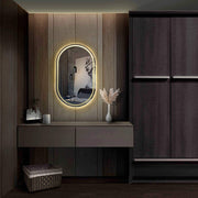 Oval frameless LED mirror with integrated backlighting, enhancing modern interior decor in a stylish room.