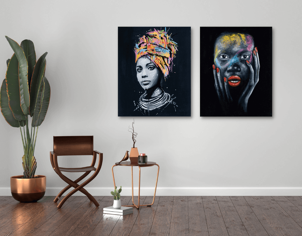 Two vibrant canvas artworks of women with bold colors, styled in a modern room with a plant and wooden flooring.